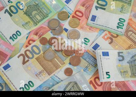 Accumulo di banconote e monete in euro Foto Stock