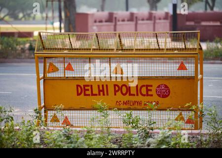 Barriera stradale gialla della polizia di Delhi tra strada di blocco per persone e auto, barriera stradale della polizia di Malviya Nagar che gestisce il flusso di persone e ve Foto Stock