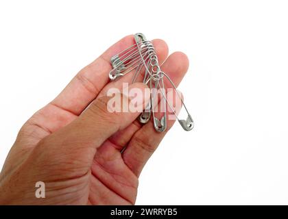 Tenere a mano molti perni da cucire isolati su sfondo bianco Foto Stock