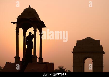 Sagoma della statua di Subhas Chandra Bose sotto il baldacchino dietro il memoriale di guerra della porta dell'India nel glorioso tramonto, statua monolitica di Netaji realizzata in granito nero Foto Stock