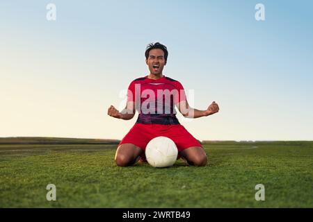 Giovani calciatori sfoggiano emozioni e gioia dopo aver vinto e festeggiato il successo sul campo da calcio Foto Stock