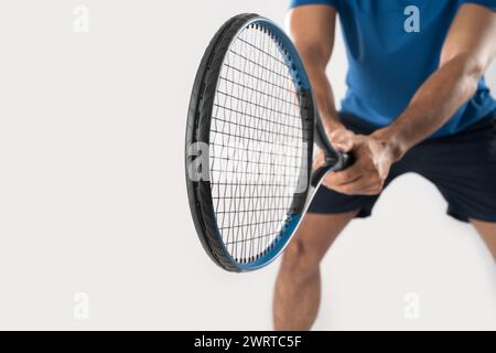 Tennista maschile in piedi tenendo la racchetta da tennis con gesti decisi su sfondo bianco. Foto Stock
