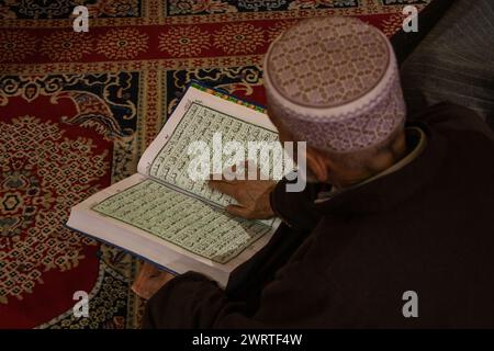 14 marzo 2024, Srinagar, Kashmir, India: Un musulmano del Kashmir viene visto leggere il Corano mentre prega all'interno di un santuario il terzo giorno del mese islamico del Ramadan a Srinagar. Il Ramadan è il nono mese del calendario islamico e ha un significato speciale nell'Islam. I musulmani credono che durante questo mese, i primi versi del Corano, il libro sacro dell'Islam, siano stati rivelati al profeta Maometto. (Credit Image: © Adil Abbas/ZUMA Press Wire) SOLO PER USO EDITORIALE! Non per USO commerciale! Foto Stock