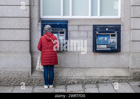 Una donna che usa un bancomat nel centro di Truro, in Cornovaglia, nel Regno Unito. Foto Stock