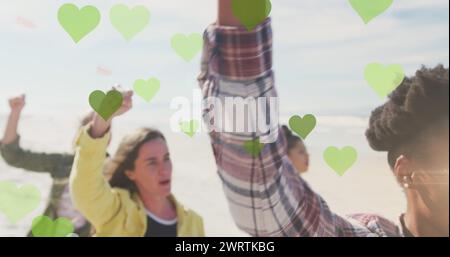 Immagine di cuori verdi su diverse persone che si alzano a pugni Foto Stock