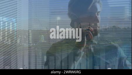 Immagine di un grafico finanziario su un uomo d'affari caucasico che usa lo smartphone Foto Stock