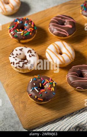 Piccole ciambelle fatte in casa per colazione con Sprinkles e Frosting Foto Stock