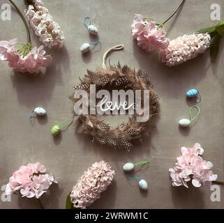 Ghirlanda di piume di quaglia circondata da fiori e farfalle Foto Stock