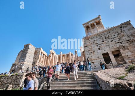Atene, Grecia - 2 marzo 2024: Vista dei visitatori e del Tempio di Atena Nike Propileo Antica ingresso alle rovine dell'Acropoli Foto Stock