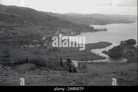 1970, storica, una vista dalla collina circostante su Ambleside nel Lake District, Cumbria, Inghilterra, Regno Unito, che mostra il paesaggio ondulato e il famoso lago windermere con i jetties presso il Waterhead Harbour di Ambleside. Foto Stock