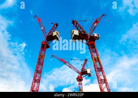 Gru da costruzione rosse contro il cielo blu, Londra, Regno Unito Foto Stock