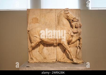 Atene, Grecia - 3 marzo 2024: Stele funerarie raffiguranti un cavallo e il suo sposo etiope (4° sec. B.C.) presso il Museo Archeologico Nazionale Foto Stock