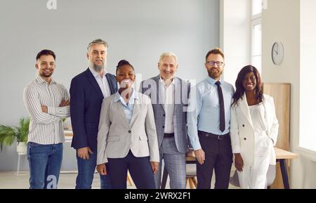 Un gruppo di uomini d'affari sorridenti che posano insieme in ufficio Foto Stock
