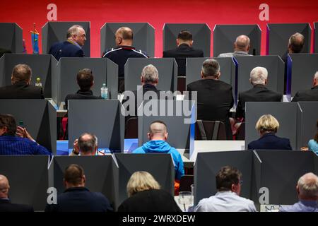 Glauchau, Germania. 14 marzo 2024. I delegati dell'AFD si siedono dietro le cabine di votazione mobili alla conferenza del partito dello stato AfD. Nei prossimi giorni, l'AfD sassone vuole stabilire la rotta del personale per le elezioni statali del 1° settembre in città. Dopo ripetuti incidenti, questa volta l'elenco degli stati deve essere redatto senza errori. L'AfD ha previsto quattro giorni per la procedura. Crediti: Jan Woitas/dpa/Alamy Live News Foto Stock