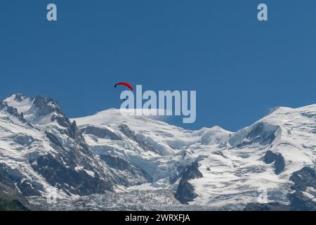 Vista del Monte bianco (4805 m), la montagna più alta d'Europa, con un parapendio rosso in estate, Chamonix, alta Savoia, Francia Foto Stock