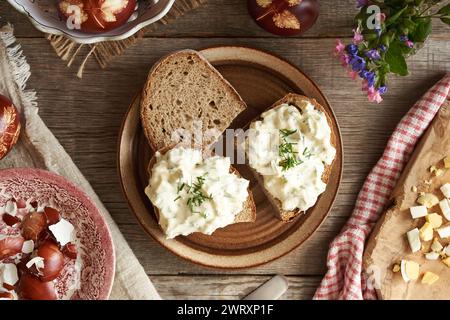 Tre fette di pane a pasta madre con spalmabile di uova di Pasqua rimaste tinte con bucce di cipolla, vista dall'alto Foto Stock