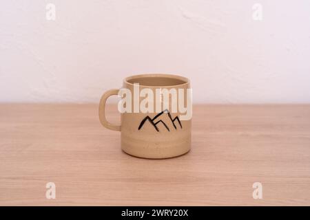 Tazza in ceramica fatta a mano con disegno di montagna. Foto di alta qualità Foto Stock