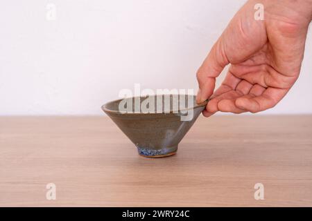 Tenendo a mano una ciotola giapponese in ceramica fatta a mano. Foto di alta qualità Foto Stock