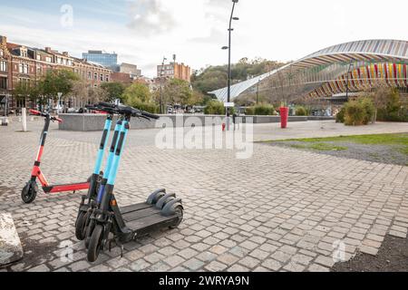 Allineato sul marciapiede della città, questa serie di scooter elettrici senza porto è pronta a trasportare gli esploratori urbani per le strade d'Europa. Un simbolo di m. Foto Stock