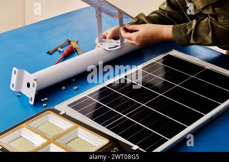 Assemblaggio fai da te della staffa di montaggio per il supporto del pannello solare e di un'illuminazione stradale a LED. Foto Stock