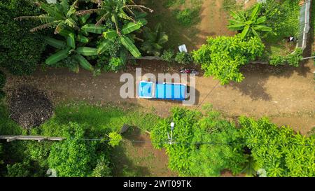 Vista aerea di un'auto blu della polizia parcheggiata accanto a una foresta in Africa Foto Stock