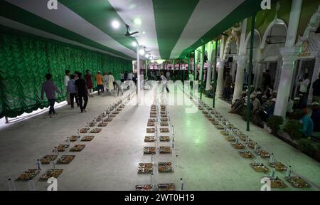 I volontari distribuiscono e organizzano file di pasto 'iftar' per i devoti per rompere il loro digiuno, durante il mese sacro del Ramadan, a Burha Jame Masjid, ON Foto Stock