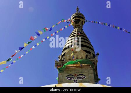 Uno stupa con bandiere di preghiera colorate di fronte a un cielo azzurro, la valle di Kathmandu, Kathmandu, Nepal Foto Stock