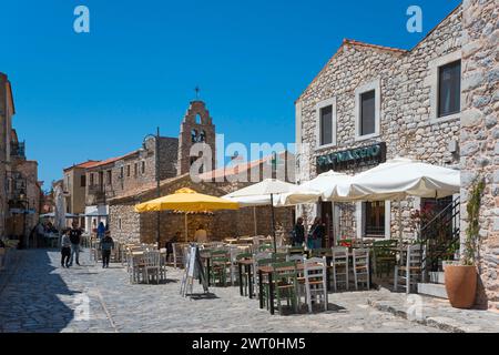 Strada soleggiata in una città vecchia con servizio catering all'aperto ed edifici tradizionali, città vecchia, Areopoli, Areopolis, Tsimova, Itylo, Anatoliki mani, mani Foto Stock