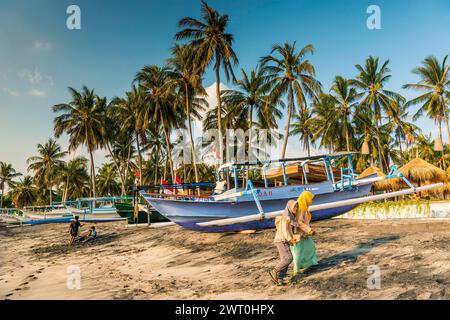 Donna musulmana al sole della sera alla spiaggia di Mangsit a Sengiggi, barca, barca da pesca, spiaggia di palme, giovani, Islam, religione, velo, viaggi, turismo Foto Stock