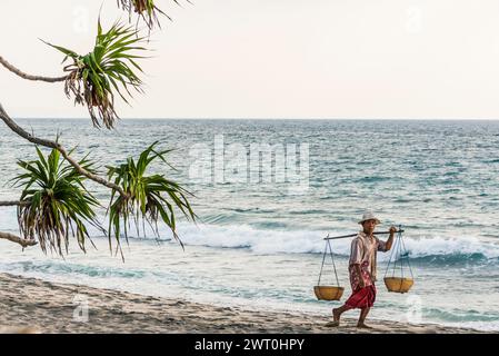 Mercante sulla spiaggia di Mangsit a Sengiggi, venditore, uomo, spiaggia di palme, viaggi, turismo, mare, spiaggia, acqua, palma, oceano, isola, costa, tropicale Foto Stock