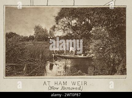 A Ham Weir (ora rimosso). Henry W. Taunt, fotografo (britannico, 1842 - 1922) intorno al 1886 una delle tre fotografie che illustrano una mappa stampata del castello di Eaton, Kempsford e dell'area circostante lungo il Tamigi. La fotografia mostra una vista di Henry taunt accovacciato sulla riva del fiume in una piccola diga. Tunt tiene la prua di una canoa che galleggia sull'acqua mentre un secondo uomo si accova vicino a lui sulla riva del fiume. La tenda fotografica di Tunt si trova in un campo dietro gli uomini. (Recto, monta) centro inferiore, sotto l'immagine, stampato con inchiostro nero: "AT HAM WEIR / (Now removed) [corsivo Foto Stock