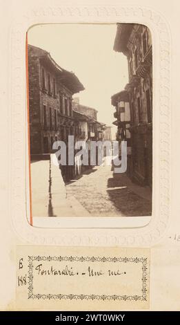 Fontarrabie - Une rue. Edmond de Labrador, fotografo (francese, attivo Bayonne, Francia anni '1860) circa 1870 Vista che guarda lungo una stretta strada nel comune di Hondarribia, noto anche come Fontarrabie. La strada curva leggermente ed è fiancheggiata da edifici alti su entrambi i lati. (Recto, Mount) in basso a sinistra, testo stampato in rosso: 'EDMOND.'; in basso a destra, testo stampato in rosso: 'ST JEAN DE LUZ'; (verso, Mount) in alto al centro, inchiostro nero: 'Rue de Fontarabie. [sic]/No 1660'; centro, etichetta rossa del produttore: "PHOTOGRAPHIE/EDMOND/ST JEAN DE LUZ."; (Recto, pagina album) centro inferiore, sotto l'immagine, inchiostro nero su carta bianca laboratorio Foto Stock