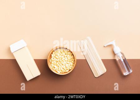 Strumenti di rimozione dei peli su sfondo marrone-beige. Prodotti professionali per la cura del corpo per una pelle liscia e setosa. Concetto di bellezza e cura. Foto Stock