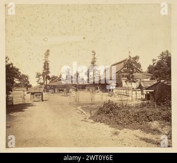 Vista interna di un complesso di templi giapponesi non identificato. Sconosciuto, fotografo anni '1850-'1890 Vista all'interno di un complesso tempio giapponese non identificato. La sala di culto principale si trova sul lato destro del cortile sterrato, di fronte a tre padiglioni all'aperto più piccoli. Tachidoro di pietra, o lanterne a piedistallo, sono sparse in tutto il cortile. Foto Stock