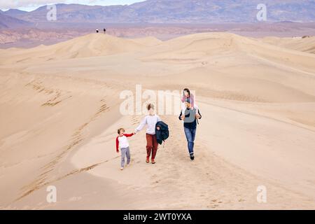 Padre e madre con bambini che camminano sulle dune di sabbia in vacanza Foto Stock
