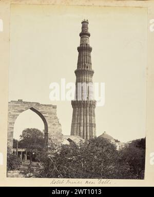 Kotūb Minar vicino a Delhi. Sconosciuto, fotografo degli anni '1850-'1890 veduta del minareto Qutb Minar, in piedi accanto ai resti ad arco della Moschea Quwwat-ul-Islam nel complesso Qutb, che fiancheggiano il cortile dietro la colonna. I resti sono decorati con motivi geometrici e iscrizioni arabe finemente scolpite, e la colonna di ferro di Delhi è parzialmente visibile sotto l'arco. (Recto, monta) al centro inferiore, sotto la stampa, scritto a mano a matita: "Kotūb Minar vicino a Delhi". Foto Stock