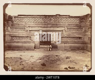 Vista 12. Emilio Herbruger, Jr., fotografo (americano, 1804 - 1894) 1875 Vista di un uomo seduto su un gradino sotto una porta all'interno delle rovine di Mitla, tenendo in mano un cappello a teglia larga. I pannelli in pietra coprono le pareti e presentano mosaici intricati di ripetizioni geometriche. (Recto, Mount) in basso a sinistra, sotto l'immagine, handwrritten in matita: "vista 12" in alto a sinistra, scritto a mano a matita: "[lateralmente] No 10" (verso, Mount) in basso a sinistra, scritto a mano a matita: "IB 89,15 - 16 (HER)" Foto Stock