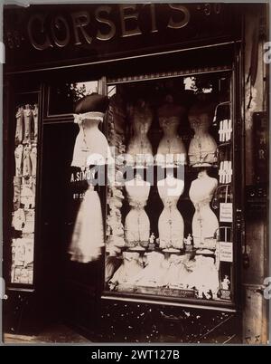 Boulevard de Strasbourg. Eugène Atget, fotografo (francese, 1857 - 1927) 1912 Vista della facciata e della finestra frontale di un negozio di corsetti. Nella finestra vengono visualizzati manichini che indossano i corsetti. Due manichini aggiuntivi sono appesi all'esterno della porta d'ingresso del negozio. (Recto, stampa) in basso a destra, inciso su negativo: '37[illeg.]'; (verso, stampa) in alto a sinistra, a matita nella mano dell'artista: 'Corsetti'; (verso, stampa) in alto a destra, a matita nella mano dell'artista: '379'; (verso, stampa) in basso a destra, a matita nella mano dell'artista: '17 bis' Foto Stock