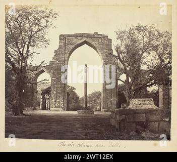 La colonna di ferro vicino a Delhi. Sconosciuto, fotografo degli anni '1850-'1890 veduta della colonna di ferro di Delhi, incorniciata dai resti ad arco della Moschea Quwwat-ul-Islam nel complesso Qutb, che fiancheggiano il cortile dietro la colonna. I resti sono decorati con motivi geometrici elaborati scolpiti e iscrizioni arabe. (Recto, monta) al centro inferiore, sotto la stampa, scritto a mano a matita: "La colonna di ferro vicino a Delhi". Foto Stock