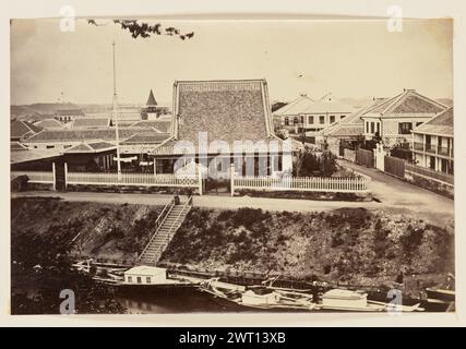 Vista sulla città. Charles Parker, fotografo (britannico, attivo negli anni '1860) circa 1864 Vista di un'area residenziale su una riva del canale. Ben visibile e' una casa a un piano con un ripido tetto di gablet e un'alta asta bandiera, circondata da recinzioni di picchetti bianchi. Altre case nella zona sono case singole e a due piani con tetti a tetto. Sullo sfondo è visibile anche una torre con tetto conico. Foto Stock