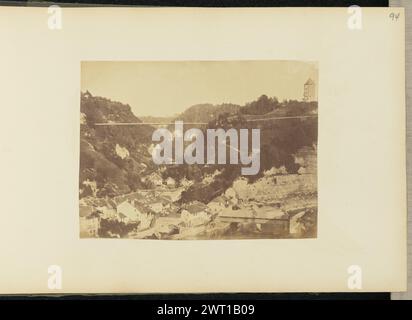 Città e montagne. Sir John Joscelyn Coghill, fotografo (irlandese, 1826 - 1905) intorno agli anni '1850 veduta di una città costruita alla base di una catena montuosa. Un fiume corre lungo il confine della città in primo piano. Un ponte coperto attraversa il fiume. Le montagne circostanti sono ricoperte di fitti alberi. (Recto, montaggio) in alto a destra, matita: "94"; Foto Stock