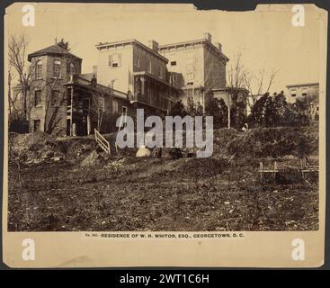 N. 103. Residenza di W.H. Whiton Esq. Georgetown, D.C.. A.J. Russell, fotografo (americano, 1830 - 1902) dicembre 1863 il bordo di un piccolo quartiere di case a più piani. Due uomini e una donna sono seduti su sedie alla base di una piccola collina erbosa accanto ad una scala di legno che conduce alle case. Foto Stock