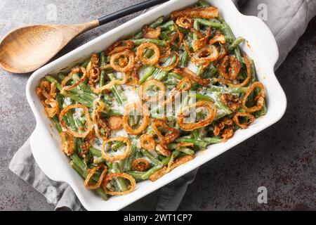 Casseruola di fagioli verdi con salsa di funghi formaggio e ricoperta da cipolle croccanti da primo piano in un piatto da forno sul tavolo. vista dall'alto orizzontale Foto Stock