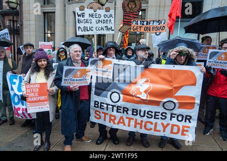 Glasgow, Scozia, Regno Unito. 15 marzo 2024. Gli attivisti di "Better Buses for Strathclyde" si riuniscono fuori dagli uffici del trasporto passeggeri di Strathclyde (SPT) prima della riunione odierna, in cui verrà presa una decisione su una mozione per riportare gli autobus attraverso Strathclyde sotto il controllo pubblico. Un modello di franchising darebbe a SPT il potere di introdurre il marchio di un singolo autobus e di regolamentare tariffe, percorsi e biglietteria. Crediti: R.Gass/Alamy Live News Foto Stock