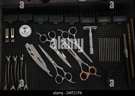 Ivano-Frankivsk, Ucraina 23 febbraio 2024: Vista di un tavolo con attrezzature da lavoro in un barbiere, vista dall'alto del tavolo. Foto Stock