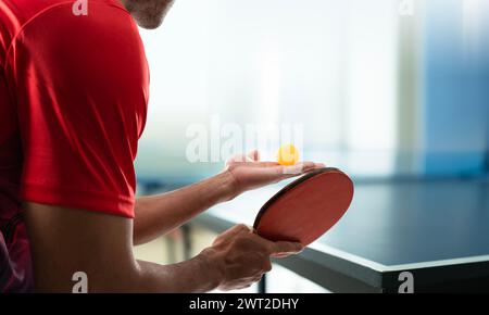 Giovane atleta che gioca a ping pong con determinazione nel gioco della vittoria Foto Stock
