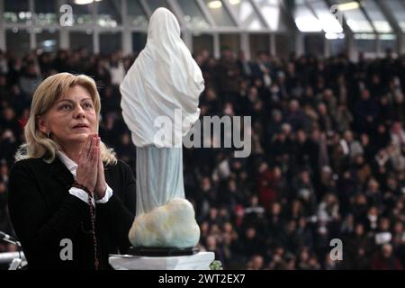 La chiaroveggente Mirjiana Dragicevic, prega di fronte alla statua di nostra Signora di Medjugorje, durante un evento religioso a Napoli Foto Stock
