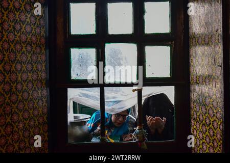 Srinagar, India. 15 marzo 2024. Le donne musulmane kashmiri pregano nel santuario di Khwaja Naqshband Sahib durante il primo venerdì del Ramadan a Srinagar. I musulmani di tutto il mondo stanno segnando il mese del Ramadan, il mese più sacro del calendario islamico in cui i devoti vanno velocemente dall'alba al tramonto. Credito: SOPA Images Limited/Alamy Live News Foto Stock