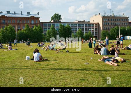 St Petersburg, Russia - 07 luglio 2012: Persone che riposano sul prato nel parco dell'isola di New Holland Foto Stock