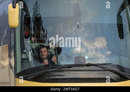 Un ucraino sorride da un autobus, carico di rifugiati ucraini in fuga dalla guerra dopo l'invasione russa, arrivando alla caserma Garibaldi di Casert Foto Stock